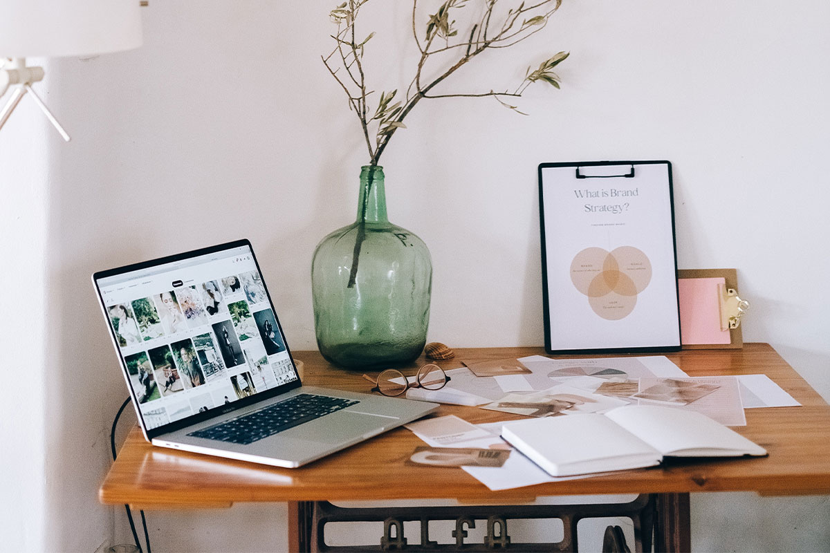 A desk with a computer and branding assets on it